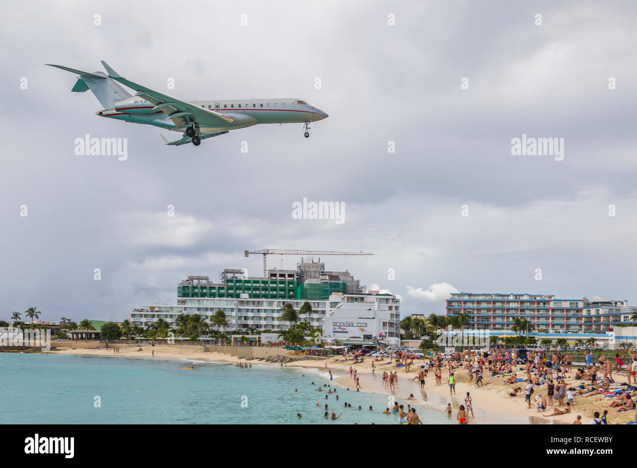 VistaJet, 9 H-VJK, Bombardier Global 6000 in niedrig über Moho Bay fliegen in Princess Juliana Flughafen in St. Marten. Stockfoto