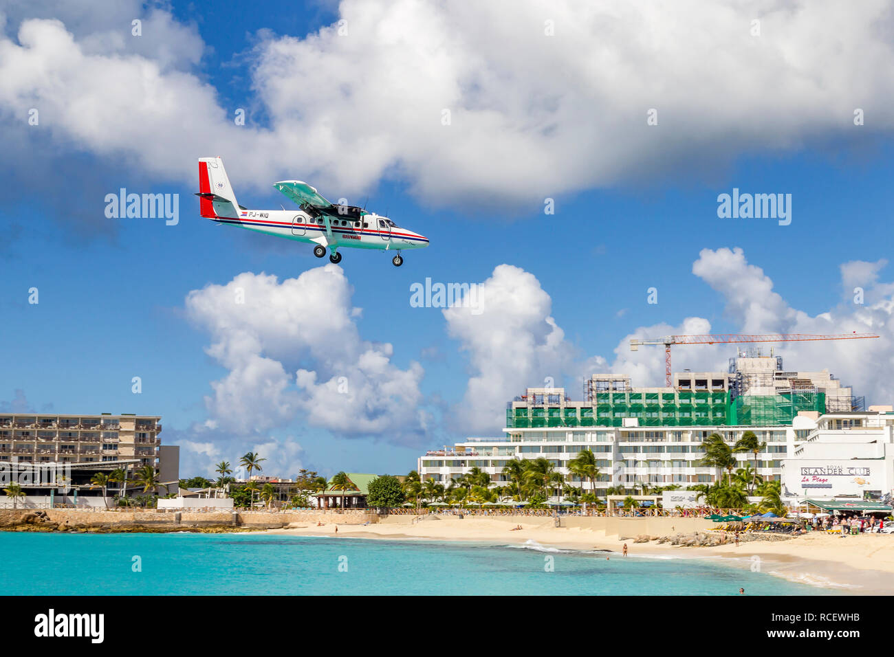 De Havilland Canada DHC -6-300 Twin Otter, PJ-WIU, Winair - Windward Islands Airways fliegen in niedrig über Moho Bay in Princess Juliana Flughafen in St. Ma Stockfoto