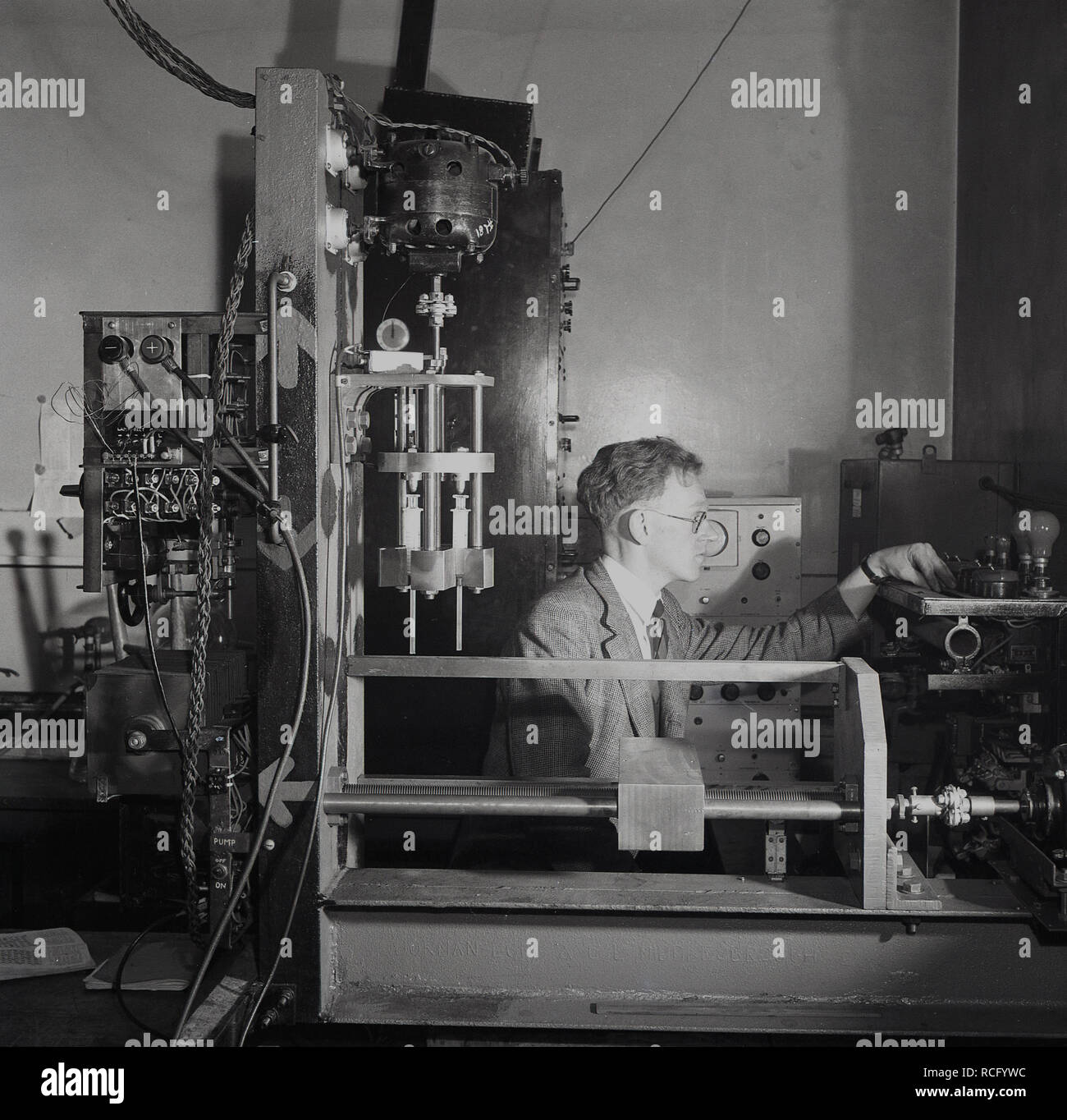 1950s, historisch, ein Wissenschaftler in einem Labor, das von den Testgeräten der Ära umgeben ist, Leeds University, Leeds, England, Großbritannien. Stockfoto