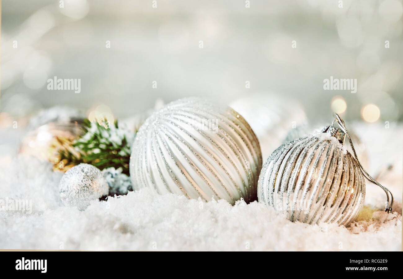Weiße Weihnachten Winter Hintergrund mit silbernen Kugeln im Schnee gegen einen funkelnden bokeh Hintergrund mit Kopie Raum für Ihren Urlaub Gruß Stockfoto