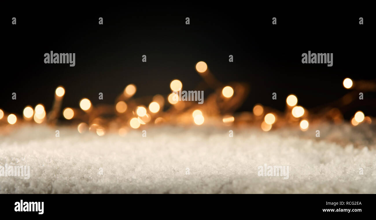 Festliche Saison Winter Karte mit Nahaufnahme des weißen Schnee gegen Weihnachten Lichter in der Nacht leuchtende Stockfoto