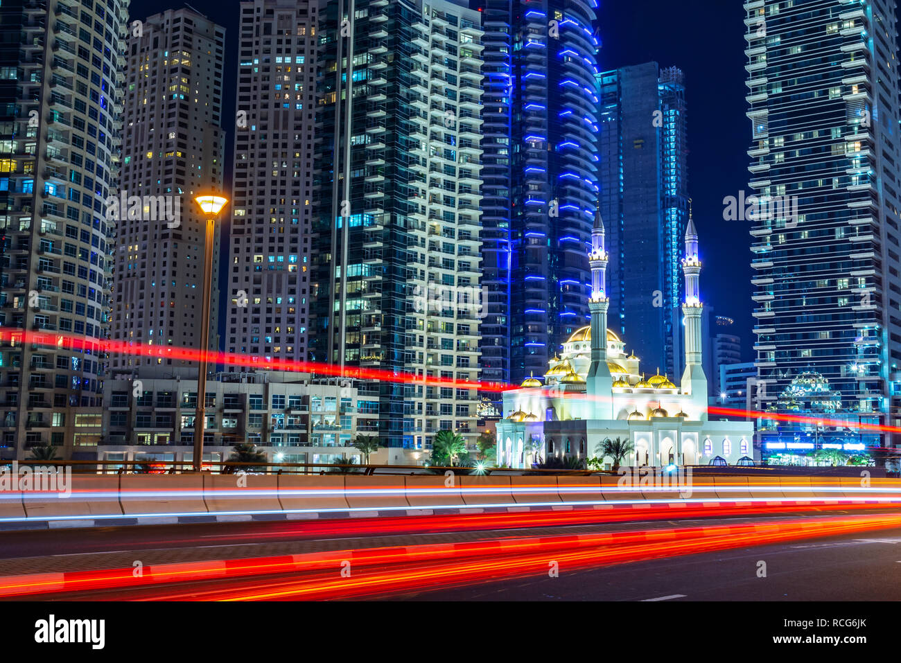 Mohammed Bin Ahmed Almulla Moschee mit Gebäuden und leichte Wanderwege in der Nacht in Dubai, Vereinigte Arabische Emirate Stockfoto