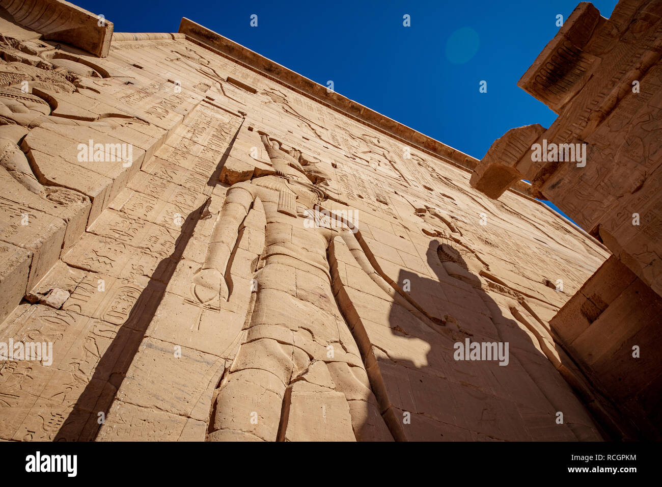 Philae T'emple Fassade mit riesigen Felsen gehauene Statue der Göttin Isis und hyeroglyphs Stockfoto