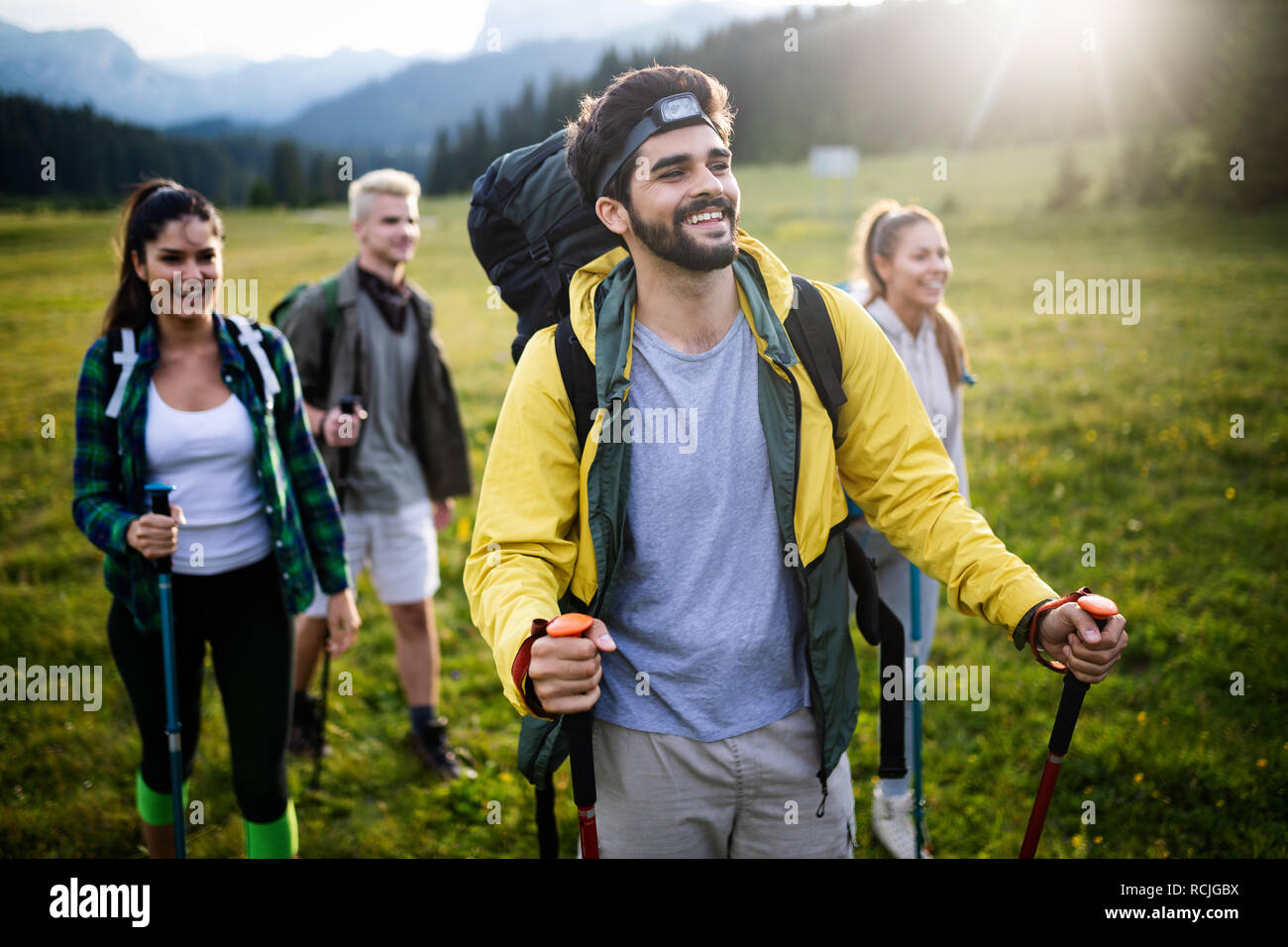 Abenteuer, Reisen, Tourismus, Wandern und Menschen Konzept - Gruppe der lächelnden Freunde mit Rucksäcken und Karte im Freien Stockfoto