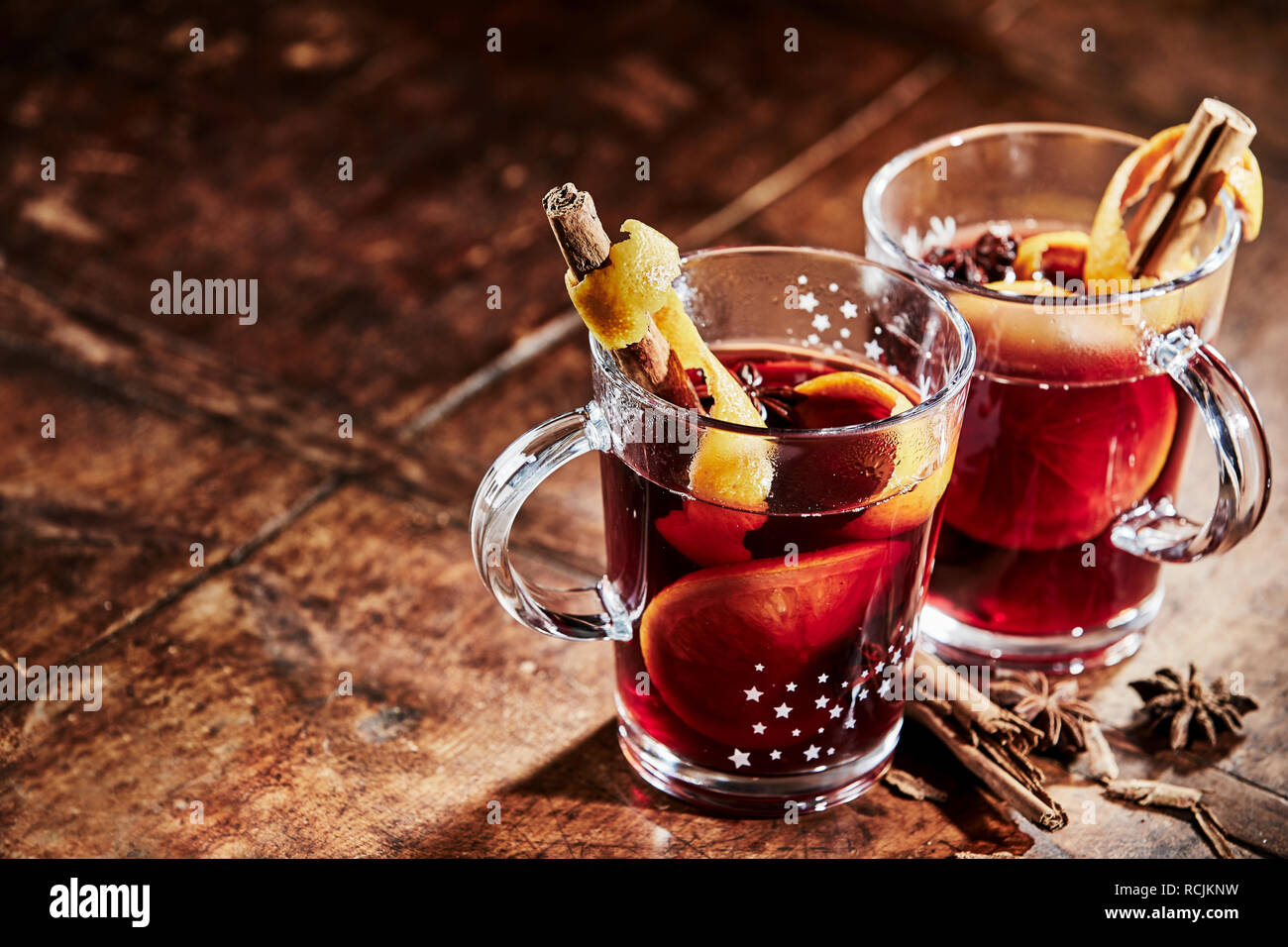 Zwei Gläser mit heißem würzigen Glühwein Weihnachten mit Stick Zimt und Sterne zu feiern Anis auf einem rustikalen Holztisch mit Kopie Raum Stockfoto