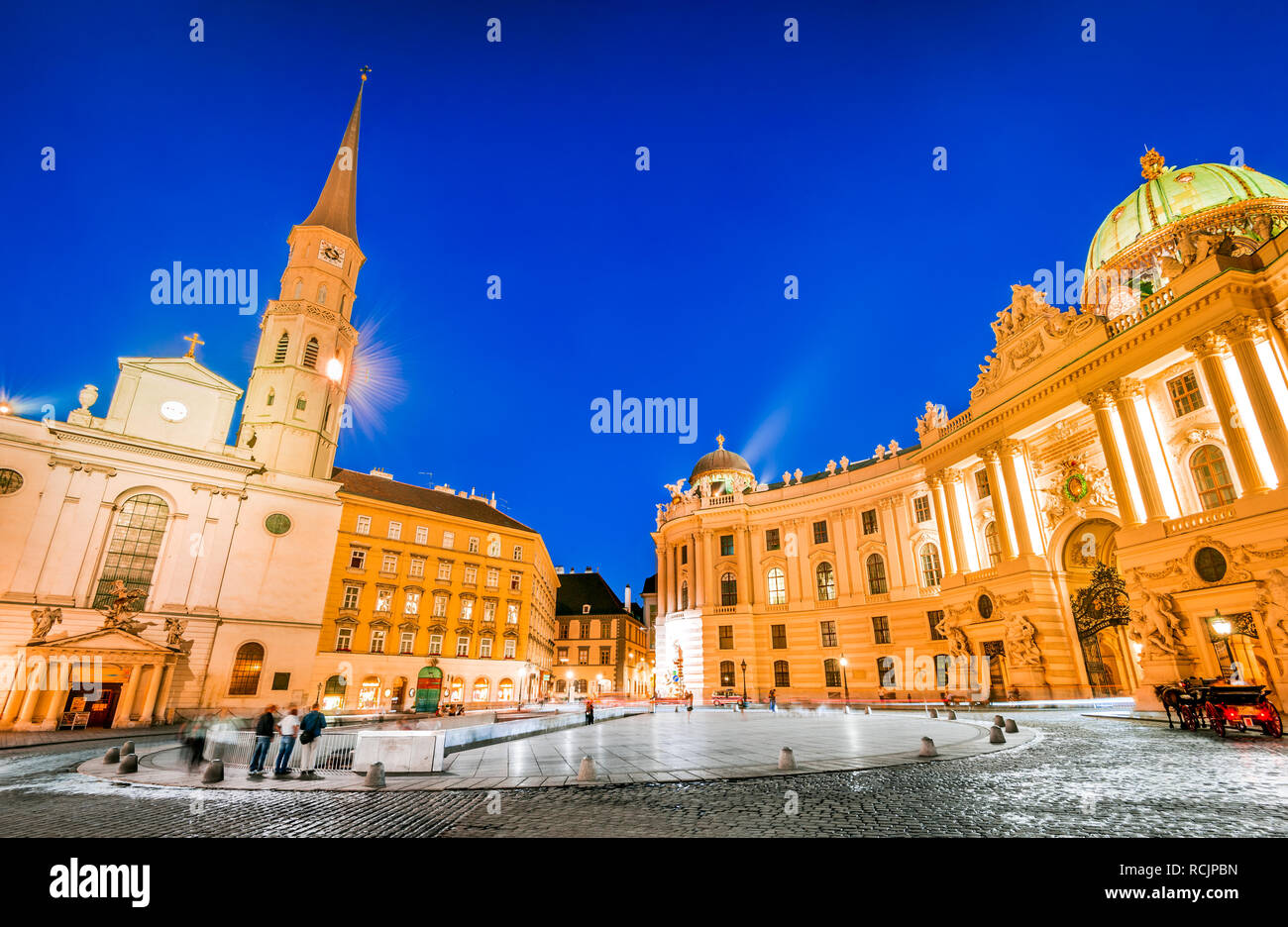 Wien, Österreich. Michaelerplatz, Weitwinkel-Blick in der Abenddämmerung mit Michaelkirche, Habsburg Empire Landmark in Wien Stockfoto