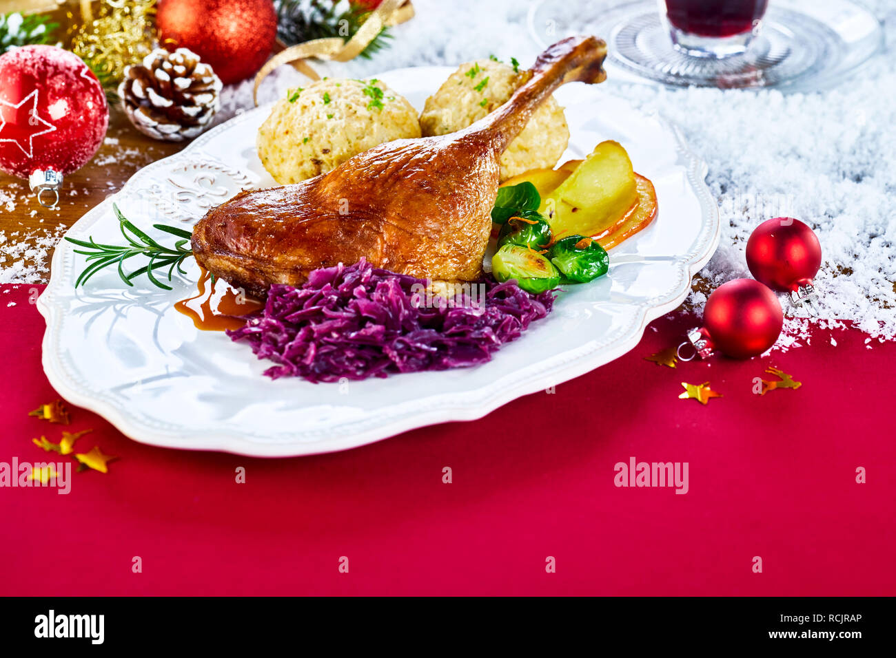 Mit der traditionellen Weihnachten gebratener Truthahn auf einer festlichen roten Tisch in einem Restaurant mit frischem Gemüse und Knödel durch Schnee und Deco umgeben Stockfoto