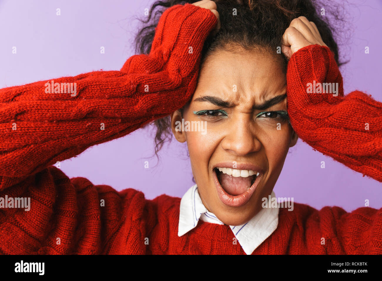 Portrait von stressigen afrikanische amerikanische Frau mit Afro Frisur schreien und greifen über Kopf gelb Hintergrund isoliert Stockfoto