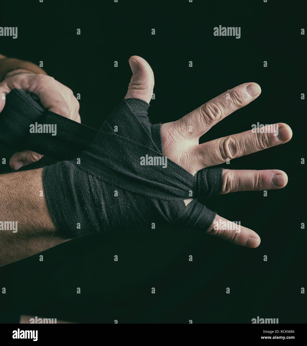 Man wickelt seine Hände in Schwarz textile Bandage für Sport, Nahaufnahme Stockfoto