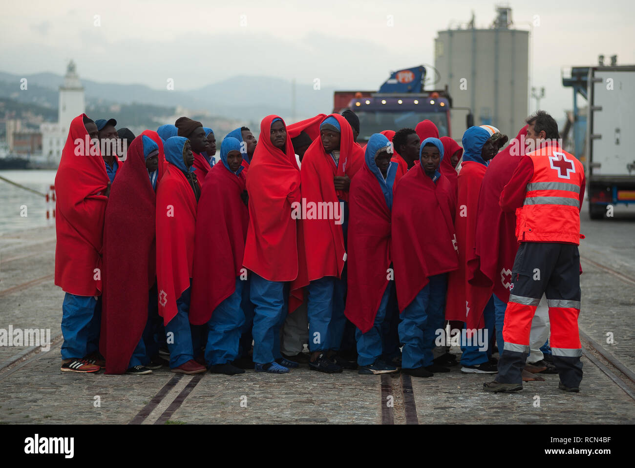 Migrantinnen und Migranten sind zu sehen, die in der Warteschlange warten, nach Ihrer Ankunft im Hafen von Malaga. Spaniens Maritime Rescue Service gerettet Insgesamt 334 Migranten an Bord sechs Jollen auf der Alboran See, und brachte sie nach Malaga Hafen, wo sie durch das Spanische Rote Kreuz unterstützt wurden. Stockfoto