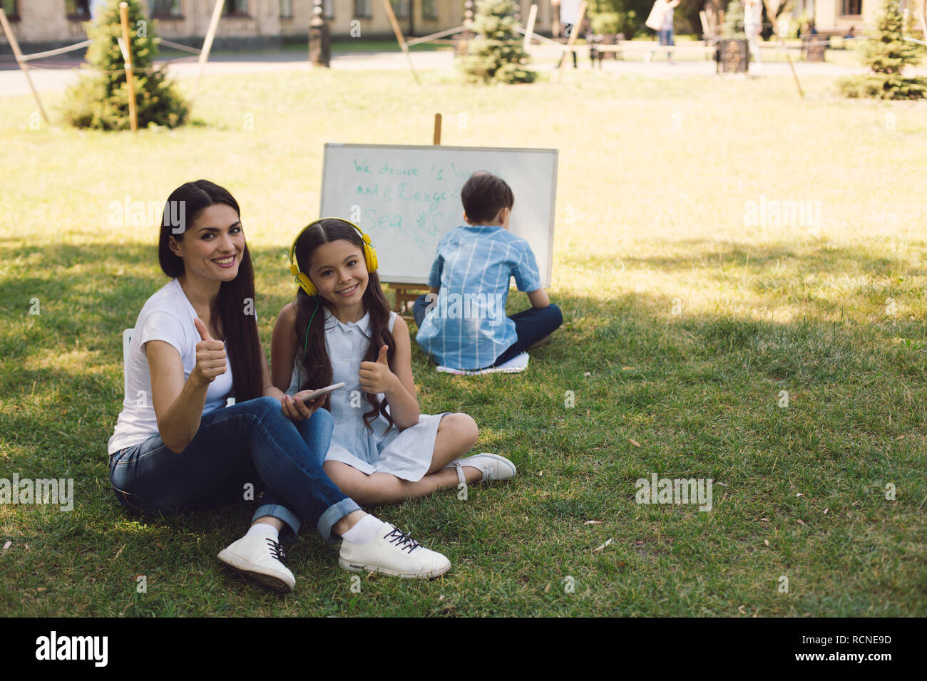 Kinder und Lehrer genießen in Park Stockfoto