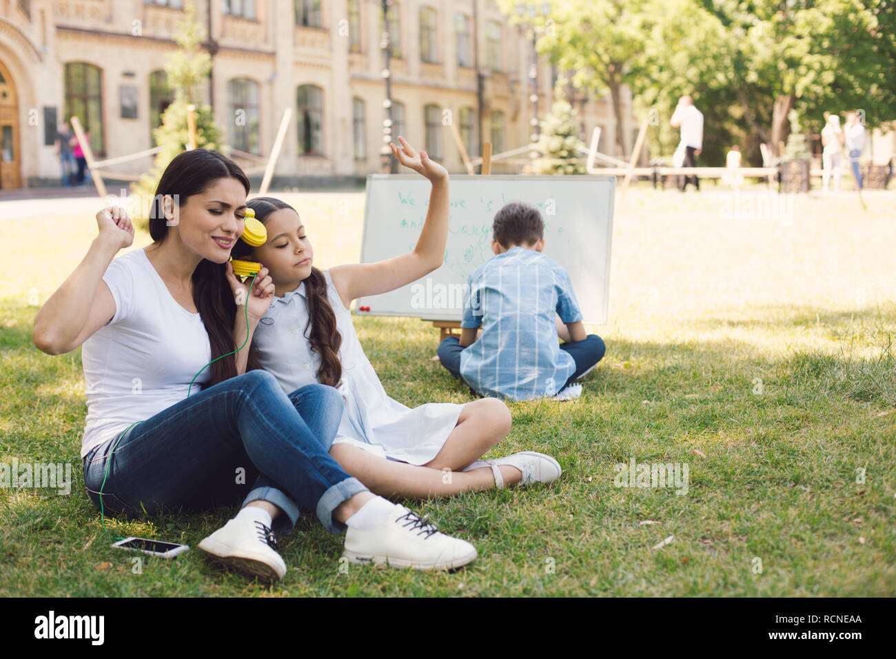 Kinder und Lehrer genießen in Park Stockfoto