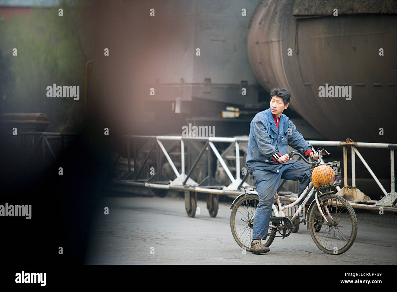 Junge männliche Bauarbeiter sitzen auf einem Fahrrad. Stockfoto