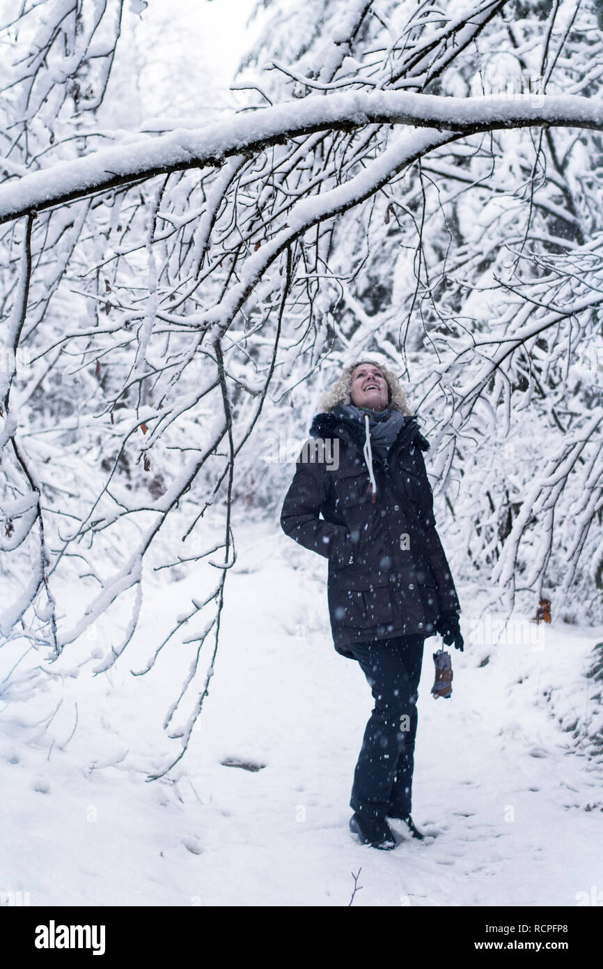Junge Frau in einem Schneegestöber in einer verschneiten Landschaft Stockfoto