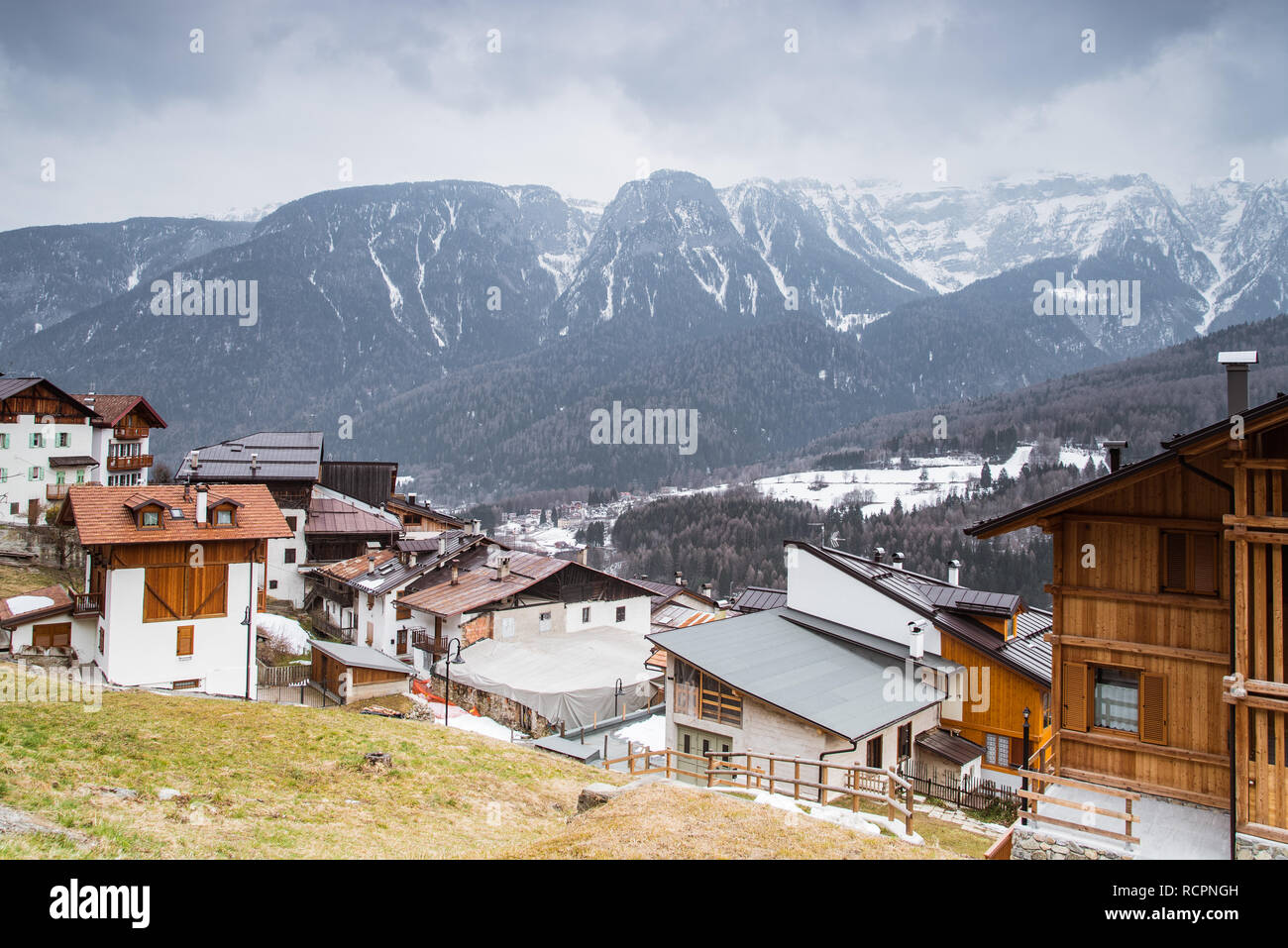 Italienische Häuser in einer kleinen Bergstadt Deggiano in der Skiregion Val di Sole, Brenta Doles schneebedeckte Berge, Trient, Trentino Alto Adige Italien Stockfoto