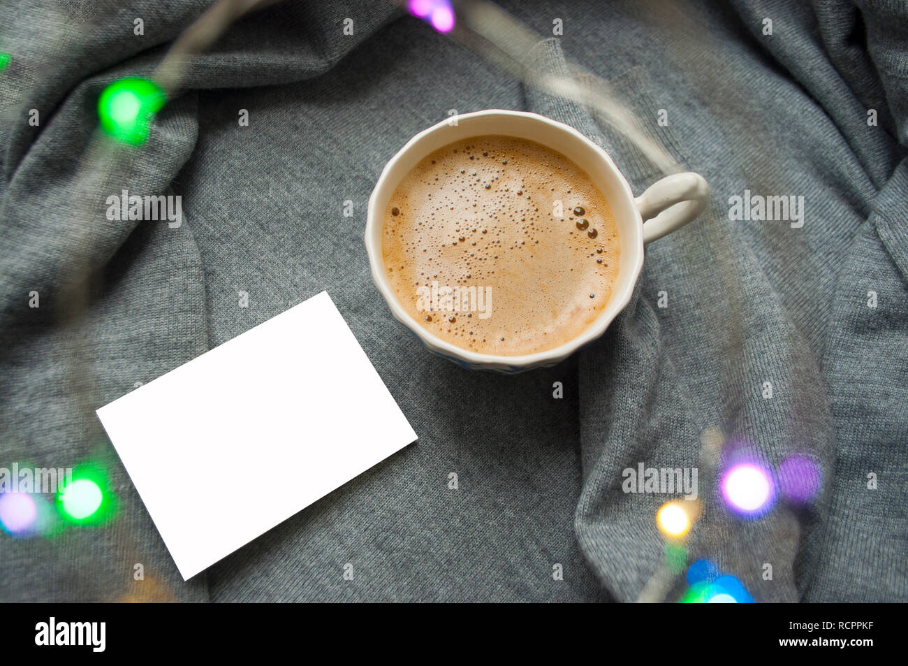 Warmes Wochenende bei kaltem Wetter. Eine Tasse Kaffee auf textile grauer Hintergrund mit Kranz und Copyspace. Stockfoto