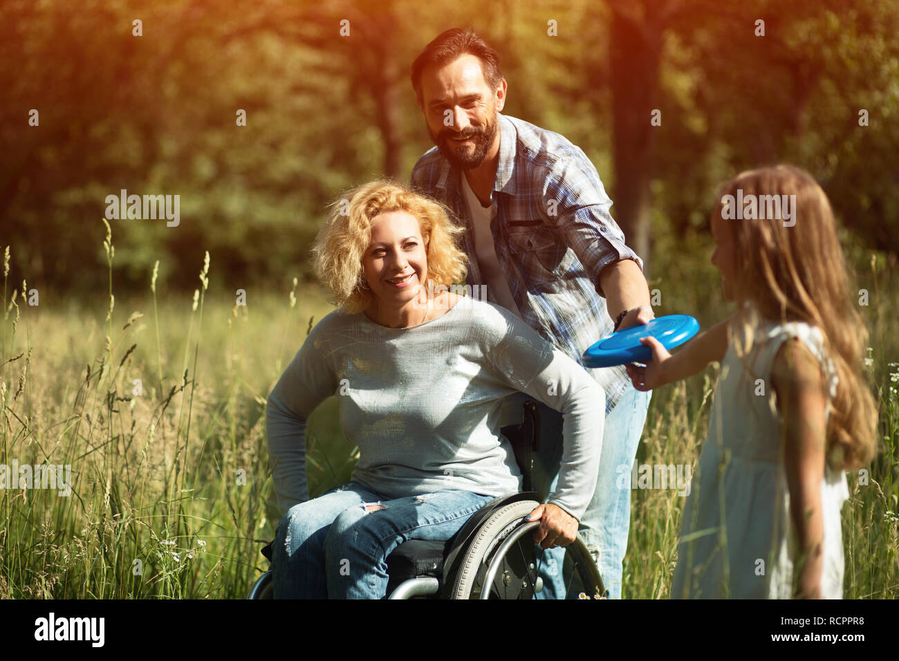 Junge Tochter Frisbeeto ihre behinderte Mutter Stockfoto