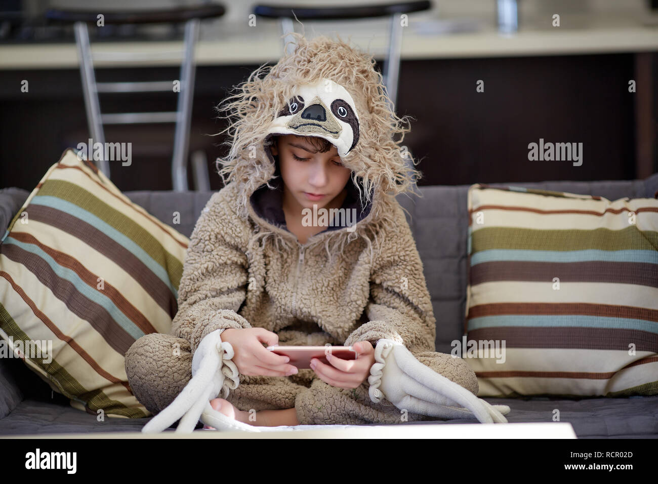 Junge in Trägheit Schlafanzug spielen Handy Stockfoto