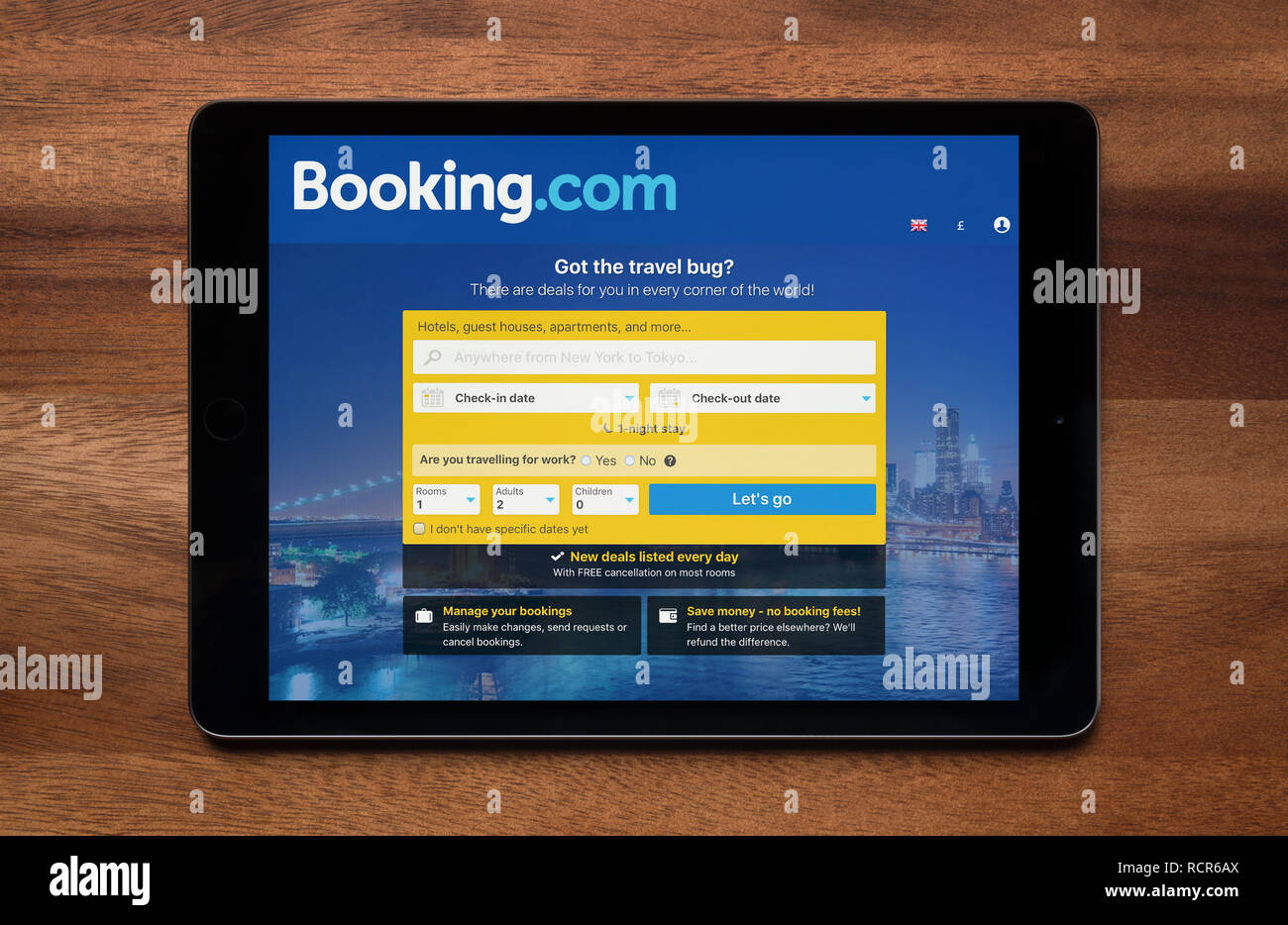 Die Website von Booking.com ist gesehen auf einem iPad Tablet, der ruht auf einem Holztisch (nur redaktionelle Nutzung). Stockfoto
