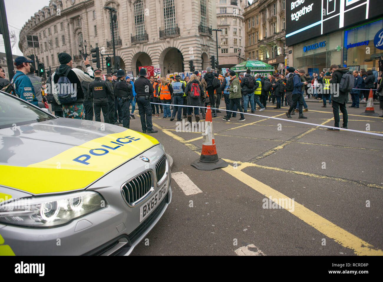 Polizeiwagen schafft eine Straßensperre in Piccadilly Circus, London, um den Verkehr vor einer nahe gelegenen Straßendemonstration zu stoppen, um die öffentliche Sicherheit zu gewährleisten. Stockfoto