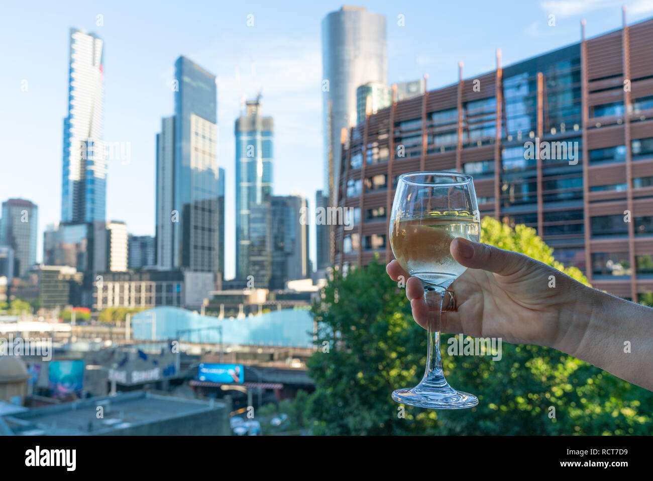 Frau Hand ein Glas australischen Wein vor der Skyline von Melbourne in Victoria, Australien Stockfoto