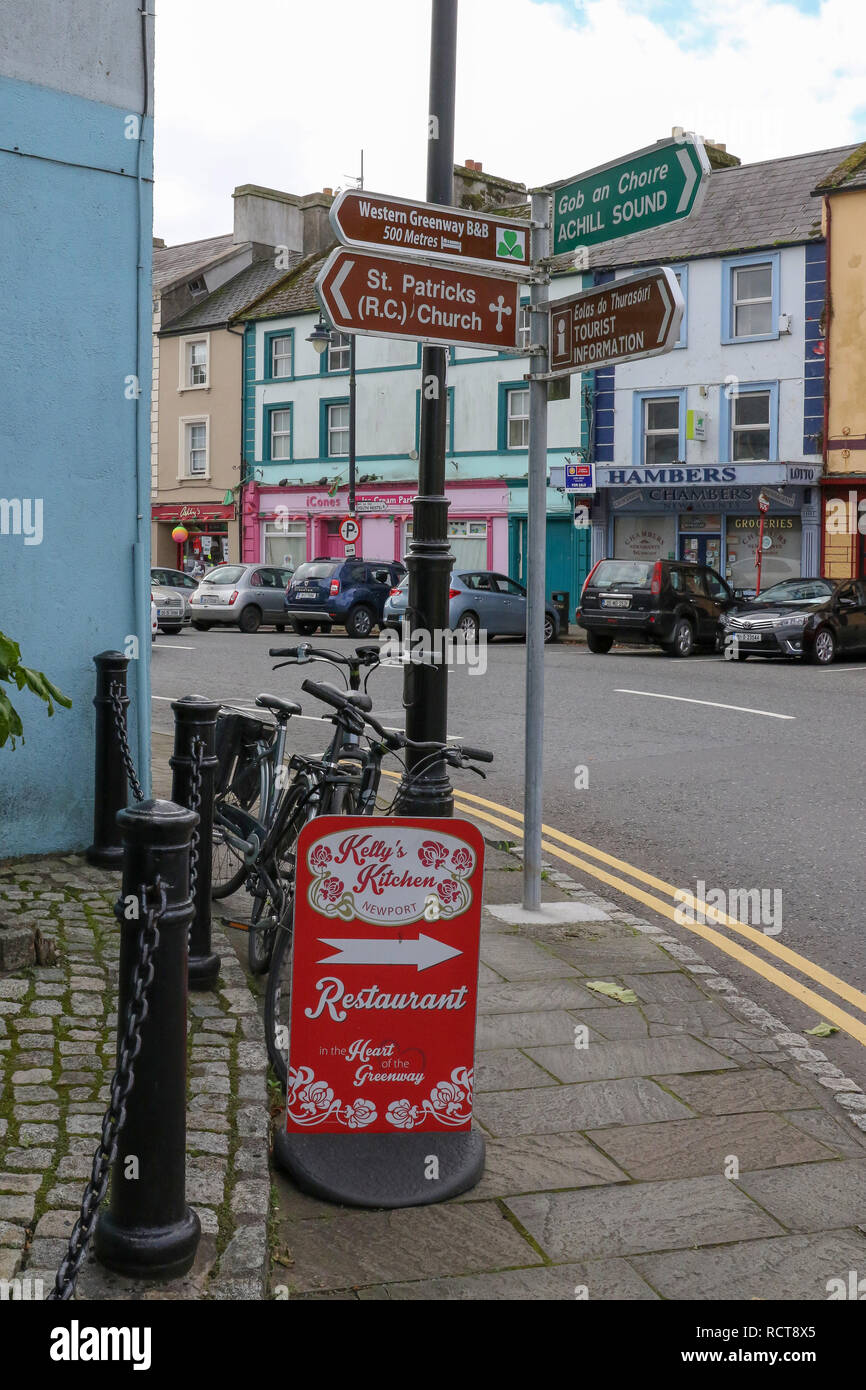 Ländliche Straßenszene in Irland mit touristischen Zeichen in einem kleinen irischen Stadt an der Spitze der Main Street, Newport, County Mayo. Stockfoto