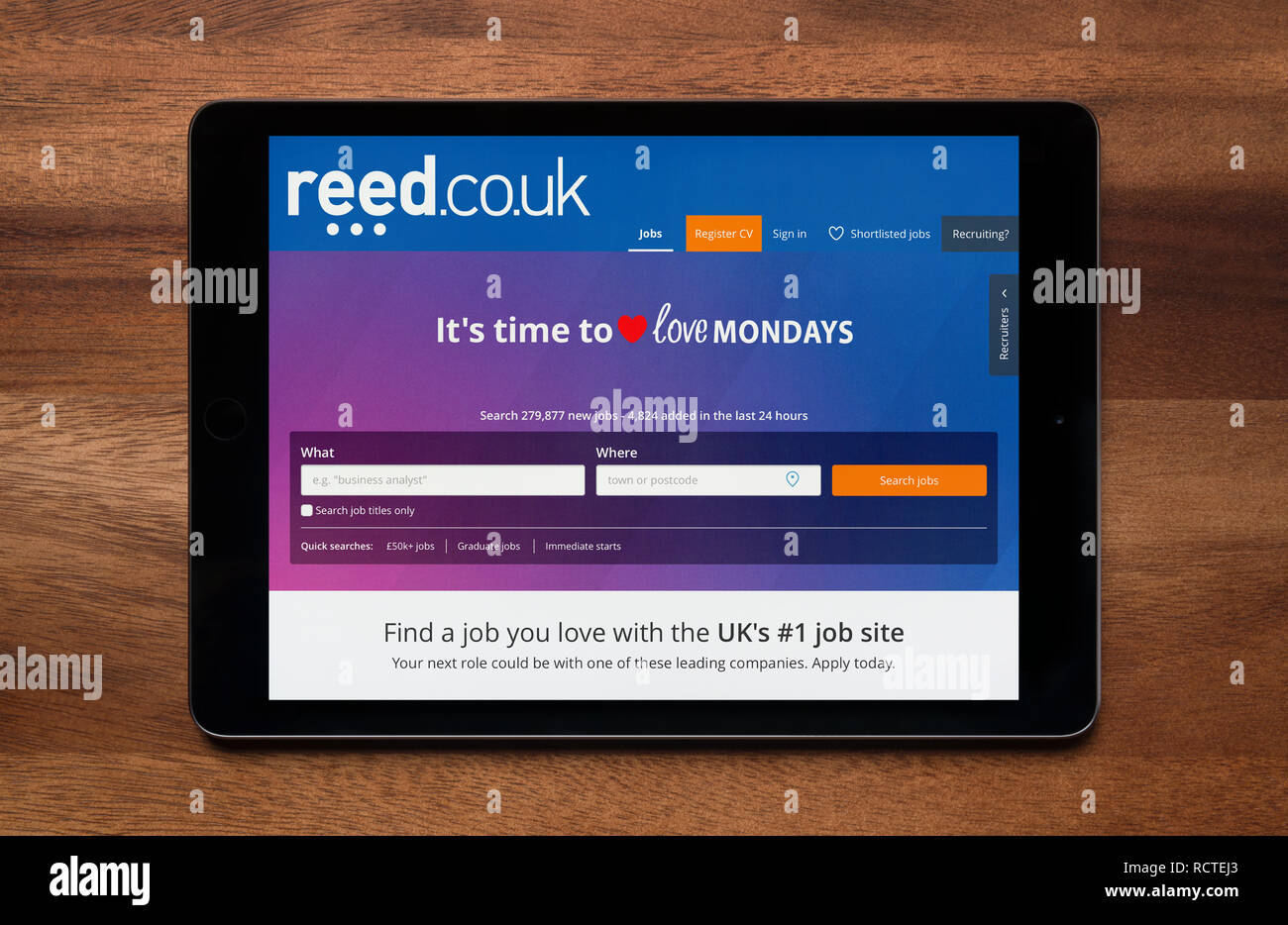 Die Website von Reed Rekrutierung ist gesehen auf einem iPad Tablet, der ruht auf einem Holztisch (nur redaktionelle Nutzung). Stockfoto