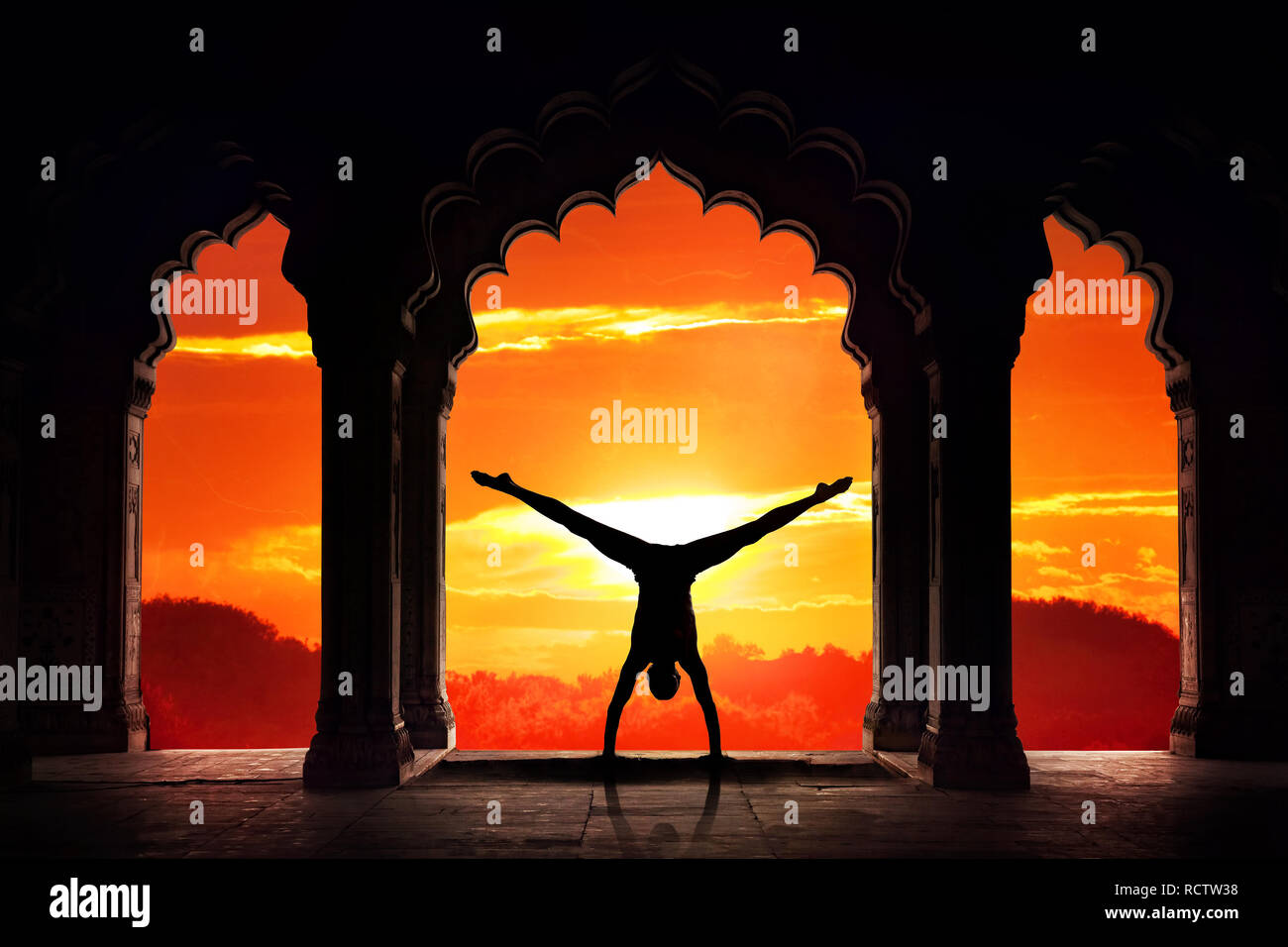 Mann silhouette Yoga voraus Handstand asana in alten Tempel in orange Sonnenuntergang Himmel Hintergrund Stockfoto