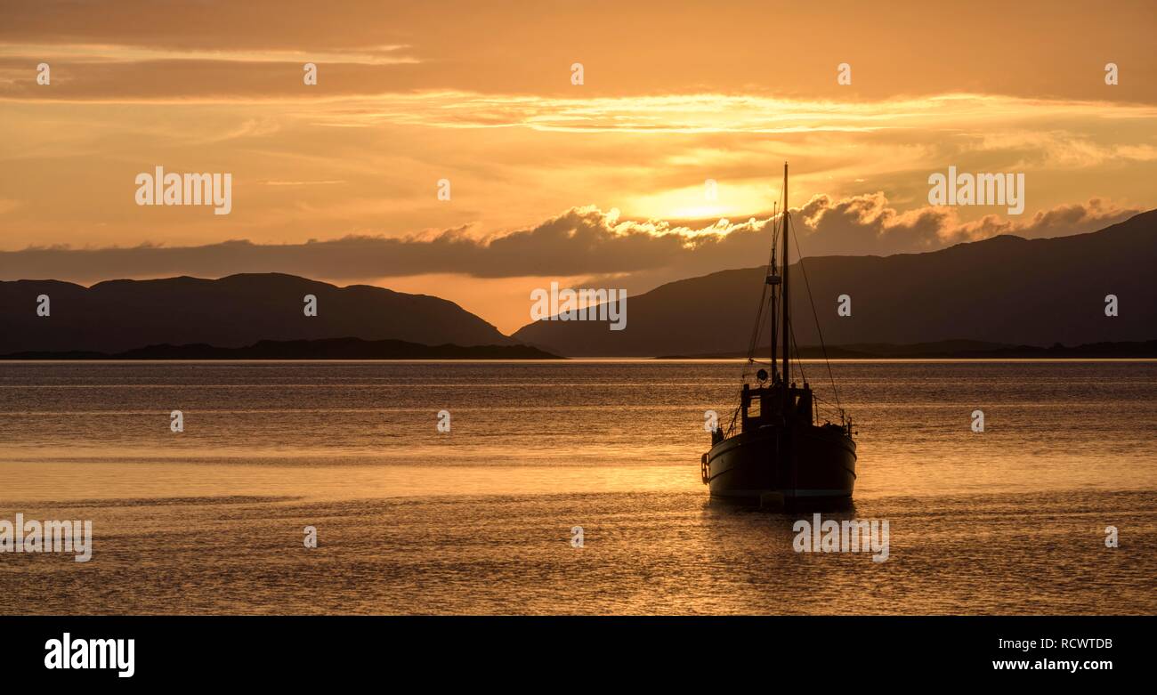 Sonnenuntergang über dem Meer und Holz- Boot, Crinan, Schottland, Großbritannien Stockfoto