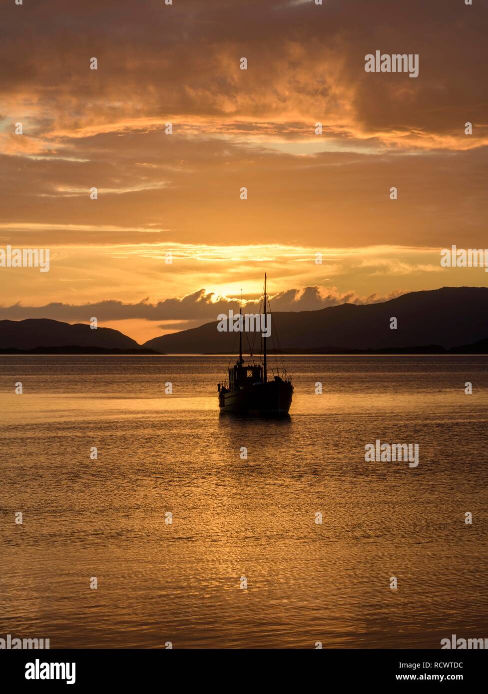 Sonnenuntergang über dem Meer und Holz- Boot, Crinan, Schottland, Großbritannien Stockfoto