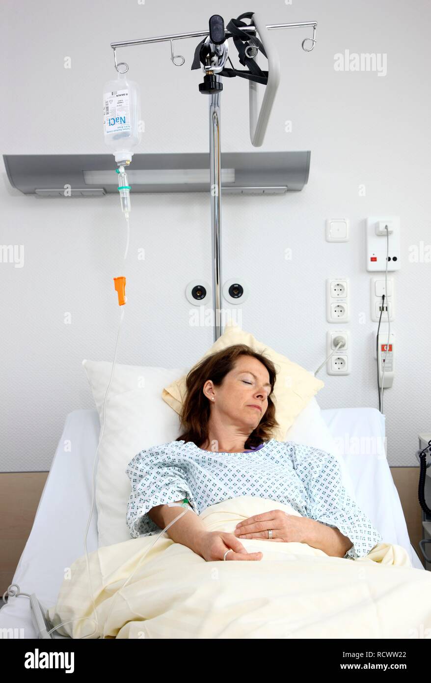 Patient liegt in einem Krankenhausbett zu einer Infusion angeschlossen, Krankenhaus Stockfoto