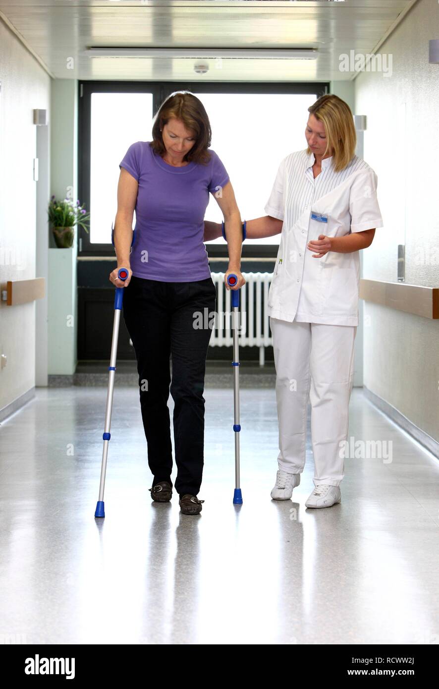 Krankenschwester bei einem Patienten versuchen, mit Gehhilfen laufen, die Mobilisierung nach der Operation im Krankenhaus Stockfoto
