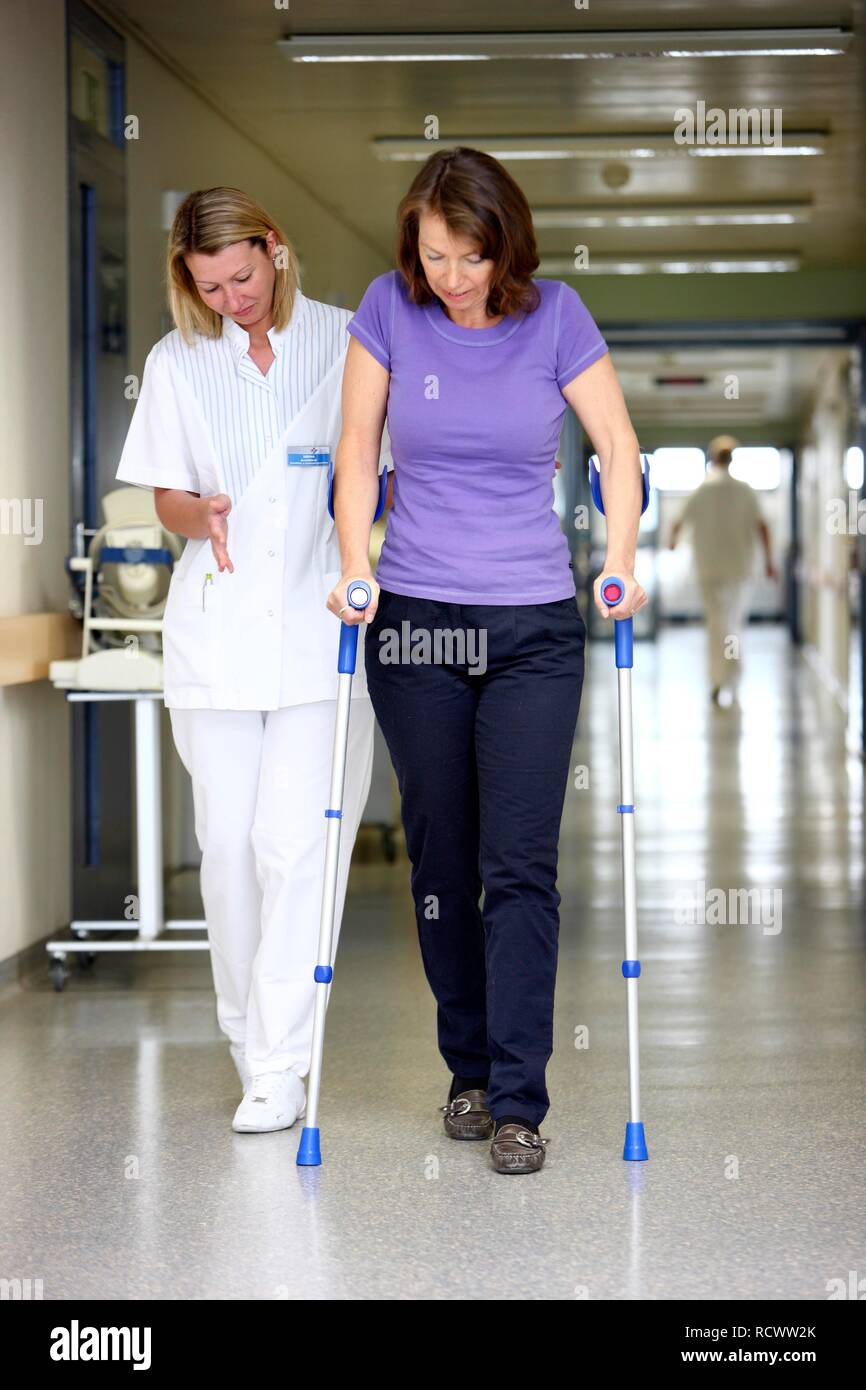 Krankenschwester bei einem Patienten versuchen, mit Gehhilfen laufen, die Mobilisierung nach der Operation im Krankenhaus Stockfoto