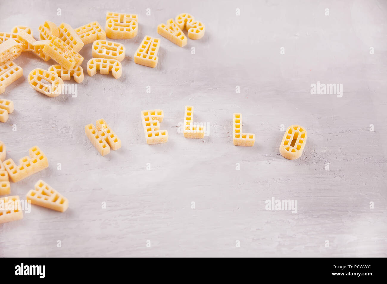Text Hallo mit Makkaroni in Form von Buchstaben auf grauem Holz- Tabelle geschrieben Stockfoto