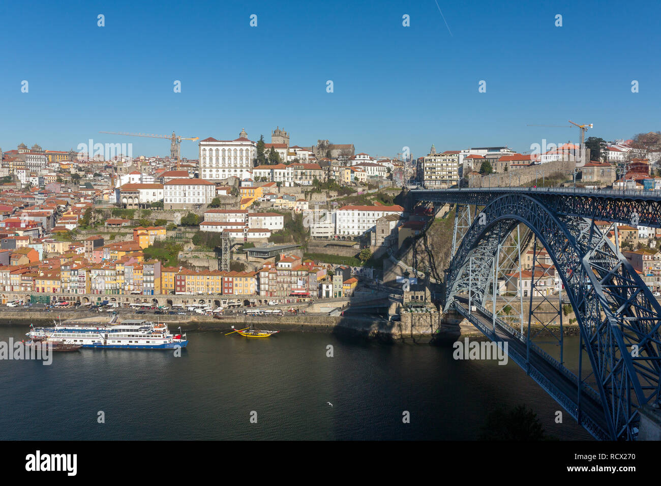 Blick auf die historische Stadt Porto mit der berühmten Brücke Ponte Dom Luis und Boote auf dem Fluss Douro, Portugal Stockfoto