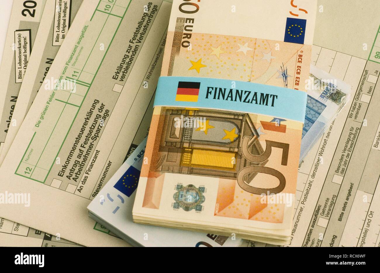 Bündel von Euro-banknoten gebunden mit einem Etikett für Finanzamt, Deutsch für Finanzamt, Einkommenssteuererklärung Formulare Stockfoto
