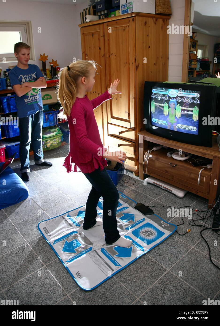 Geschwister, ein Junge, 12 Jahre alt, und ein Mädchen, 10 Jahre alt, spielen, Tanz Spiel auf Wii Spiele in Ihrem Zimmer Konsole zusammen Stockfoto