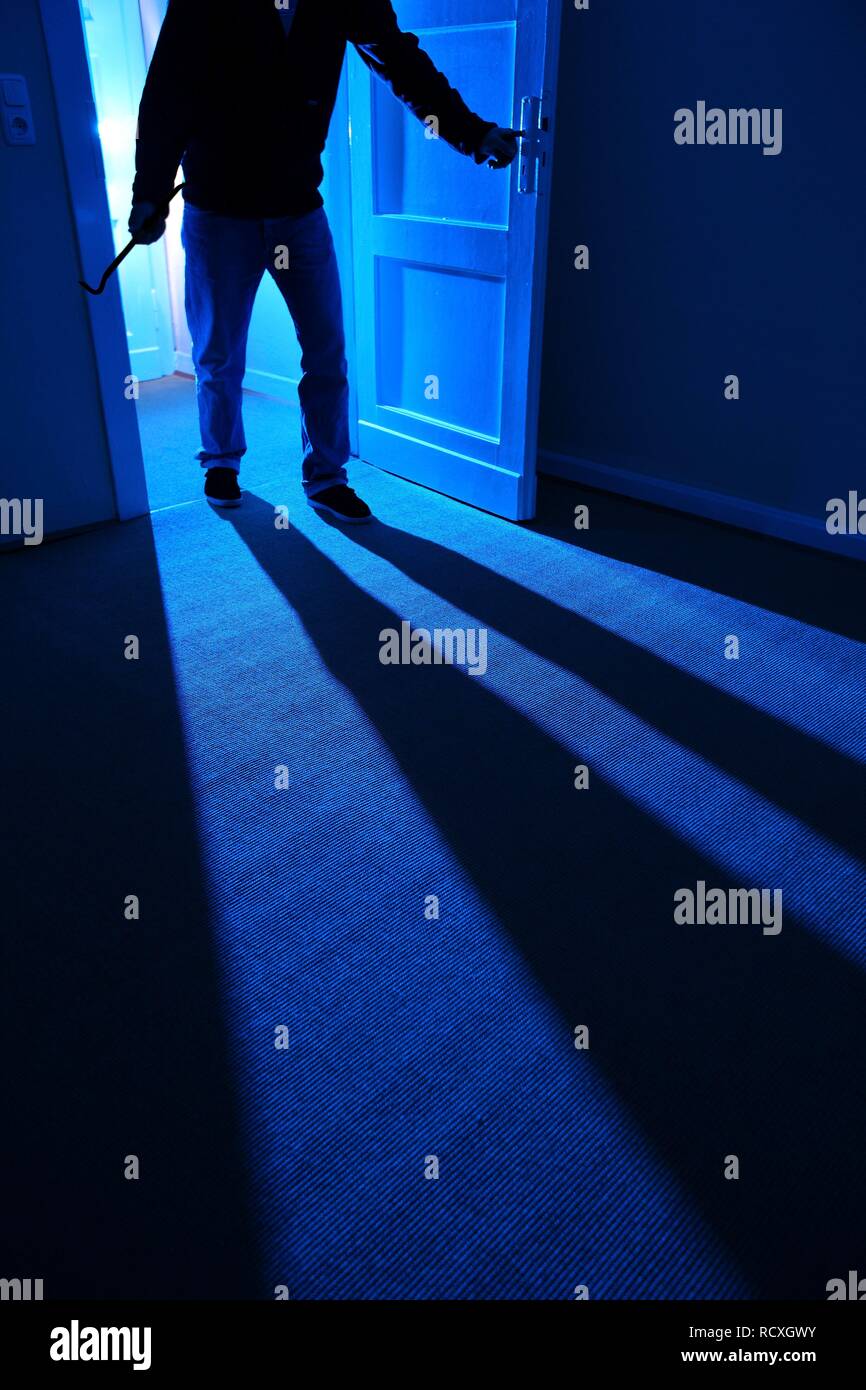 Einbrecher bricht die Tür und betritt die Wohnung, symbolische Bild für wohnungseinbruch Stockfoto