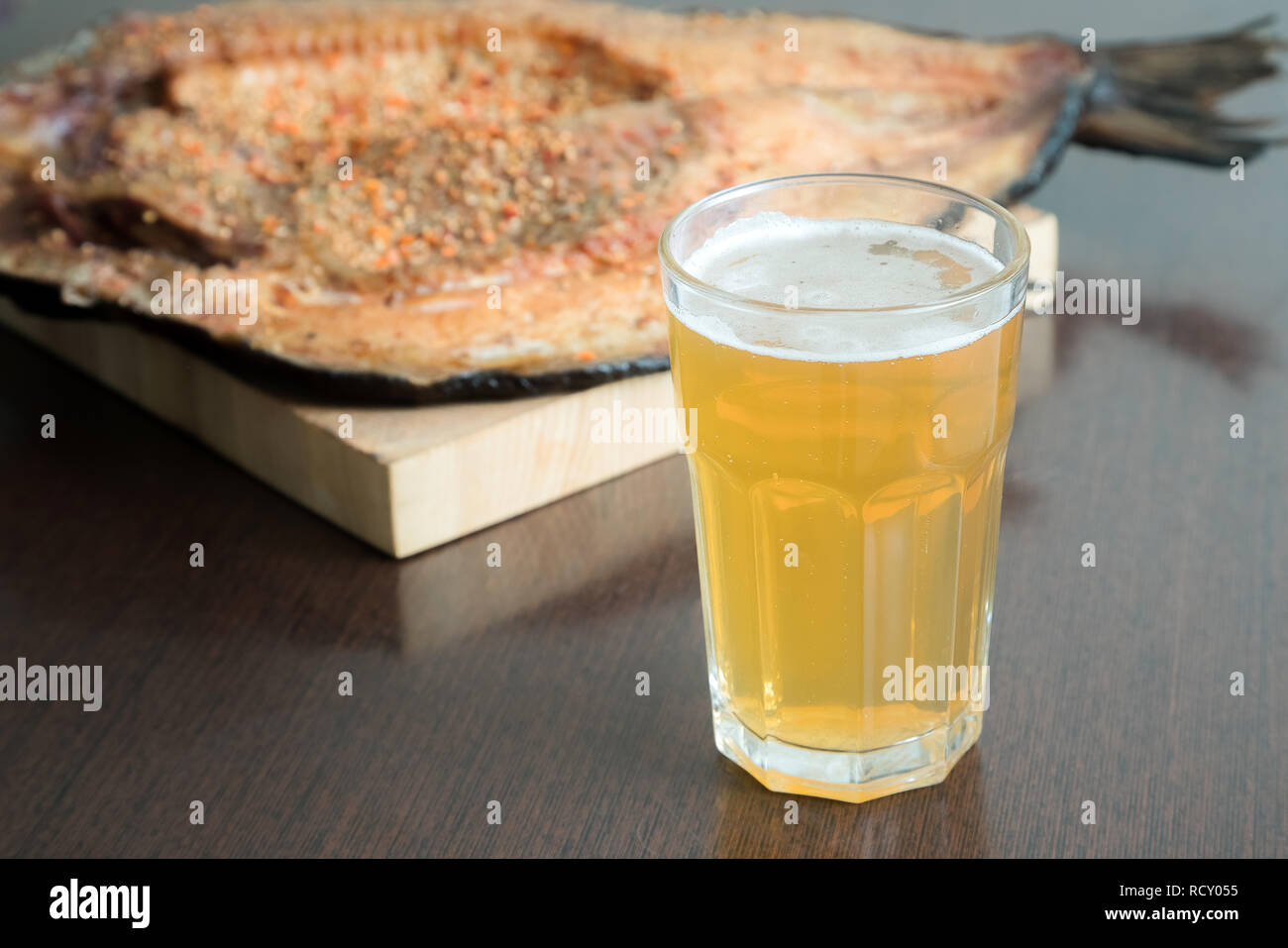 Close up horizontale Ansicht von geräucherten Fischfilets mit Gewürzen auf Holz, Karton und Glas kaltes Bier daneben Stockfoto