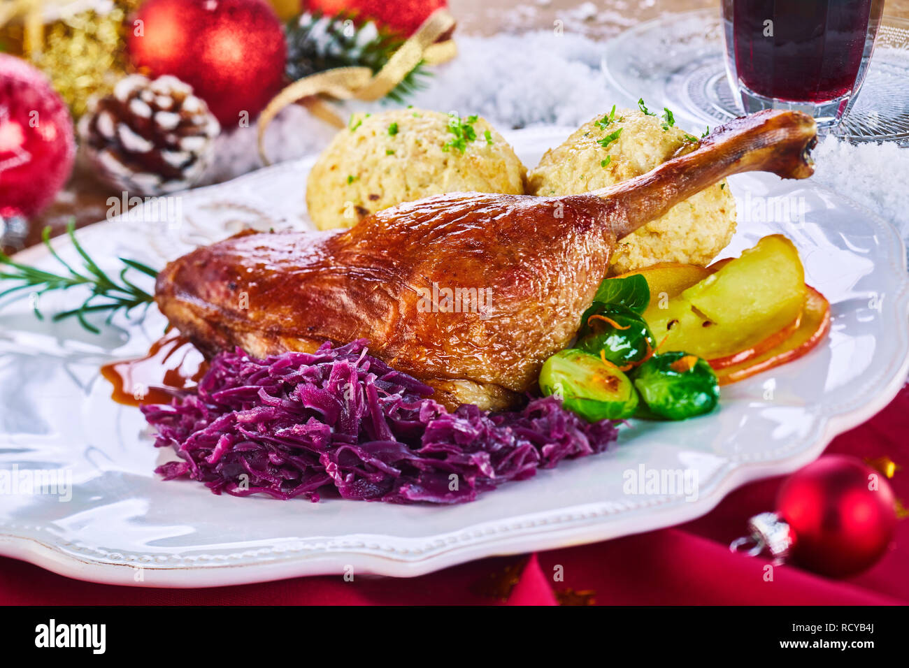 Golden gebratene Xmas Türkei Bein und Gemüse serviert auf einem Tablett von Weihnachtsschmuck auf rotem Tuch umgeben in einem Restaurant zu feiern, die der Stockfoto