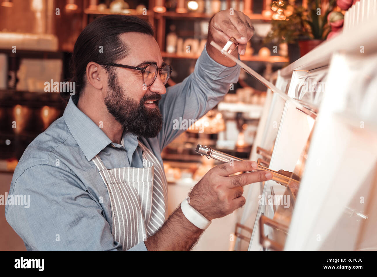 Caffee Mitarbeiter füllen der Showcase mit frischen Bäckerei Stockfoto