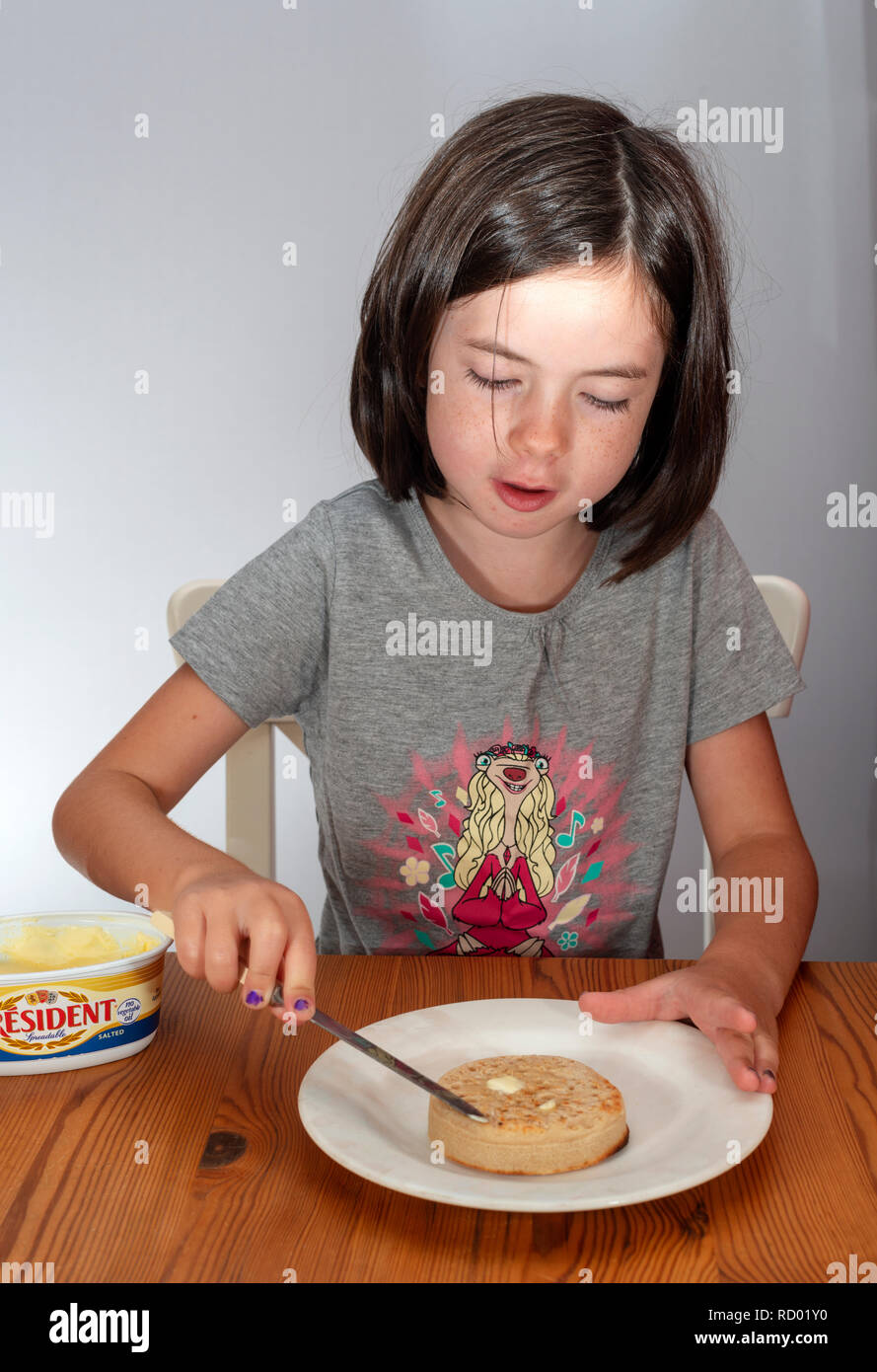 Junge Mädchen zustimmen ein geröstetes crumpet Stockfoto