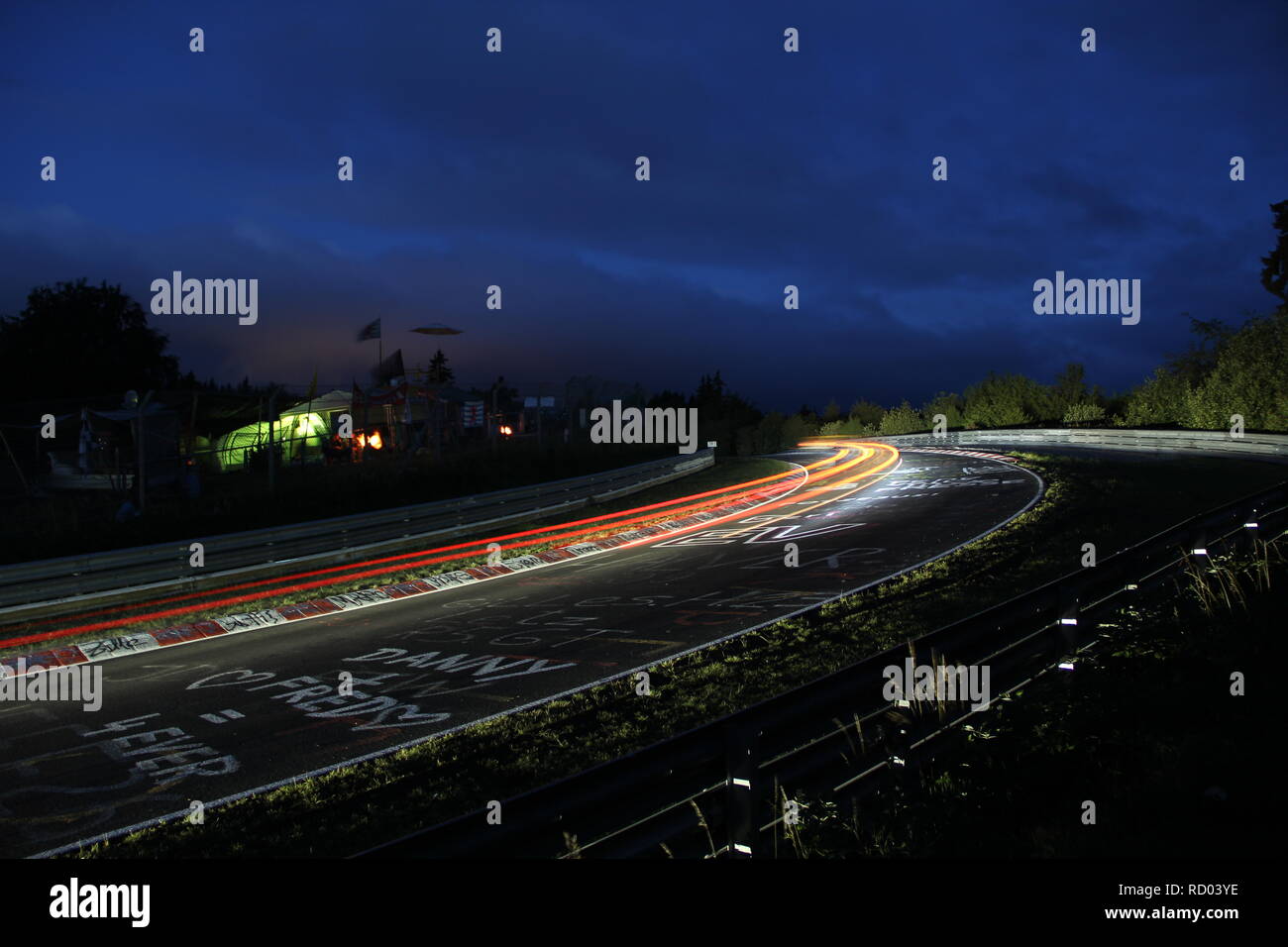 Rennwagen leuchten während des Nürburgring 24h-Rennen, langzeitbelichtung am Schwalbenschwanz Bend Stockfoto