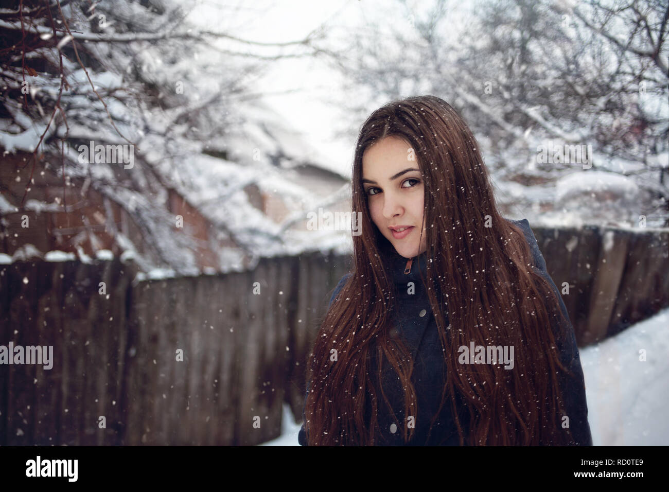 Junge schöne kaukasische Frau im Schnee auf der Straße im Winter im Freien Stockfoto