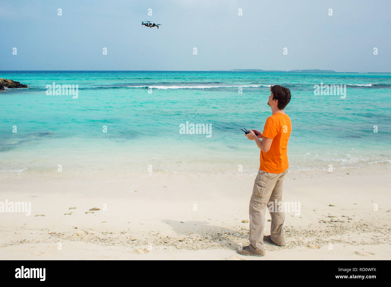 Guy startet eine Drohne über dem Meer-, Foto- und Videoaufnahmen auf quadrocopter. Drone Flüge über Wasser, Prüfung. Stockfoto