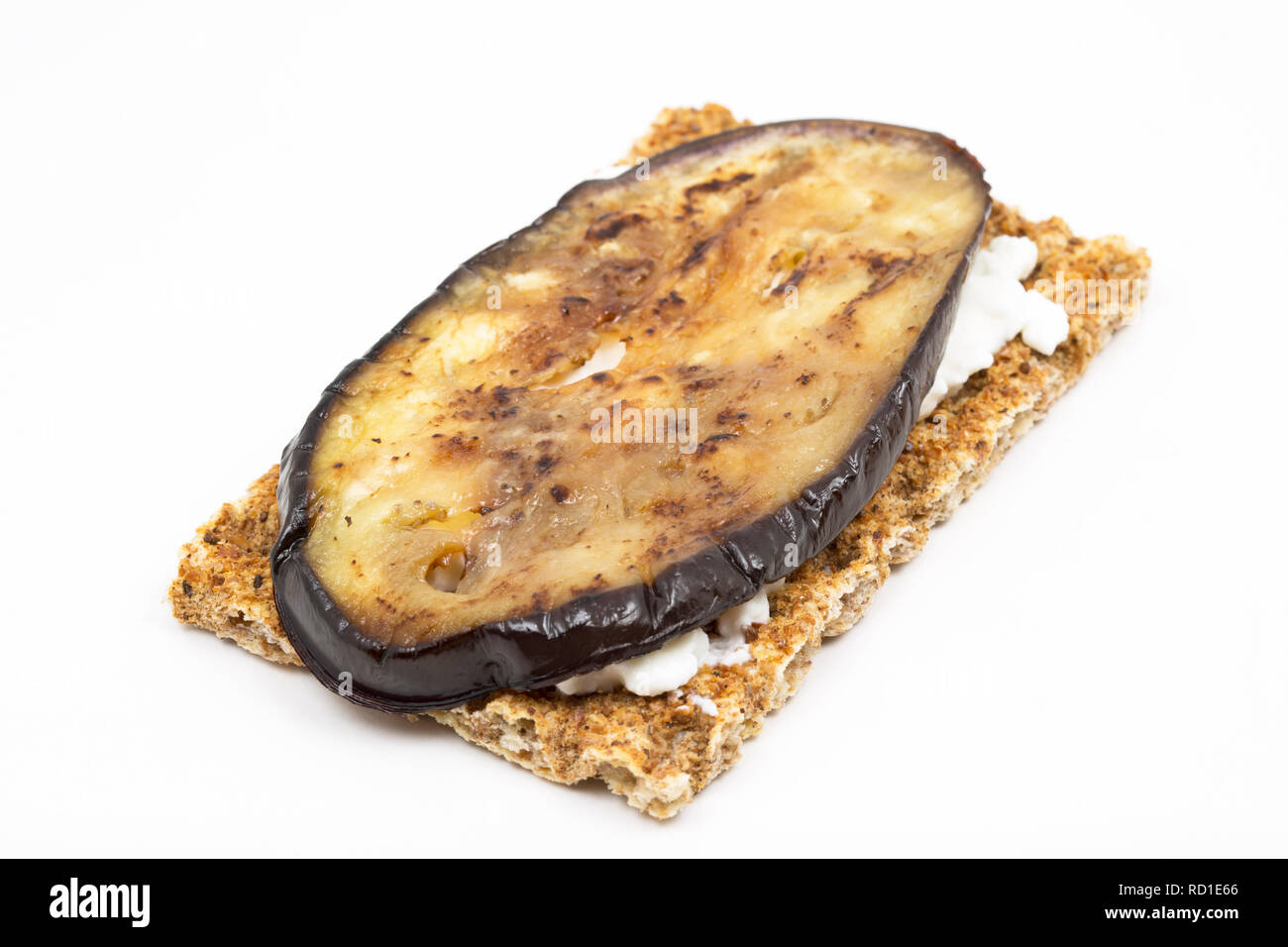 Fett frei Hüttenkäse, auf ein Roggen Brot cracker ausbreiten und garniert mit gebratenen Scheiben geschnittene Aubergine als Teil einer Gewichtsabnahme. Dorset England UK GB Stockfoto