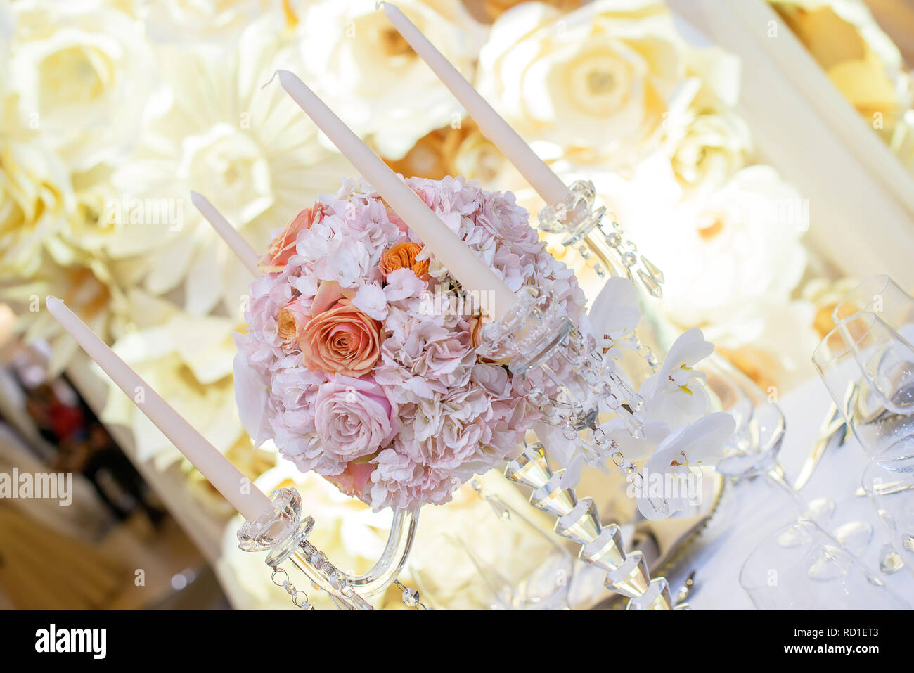 Schöne Kristallleuchter stil Kerzenhalter mit vier Scalloped bobeche und eine atemberaubende Runde Blumenstrauß in der Mitte eine Tabelle Mittelstück Stockfoto