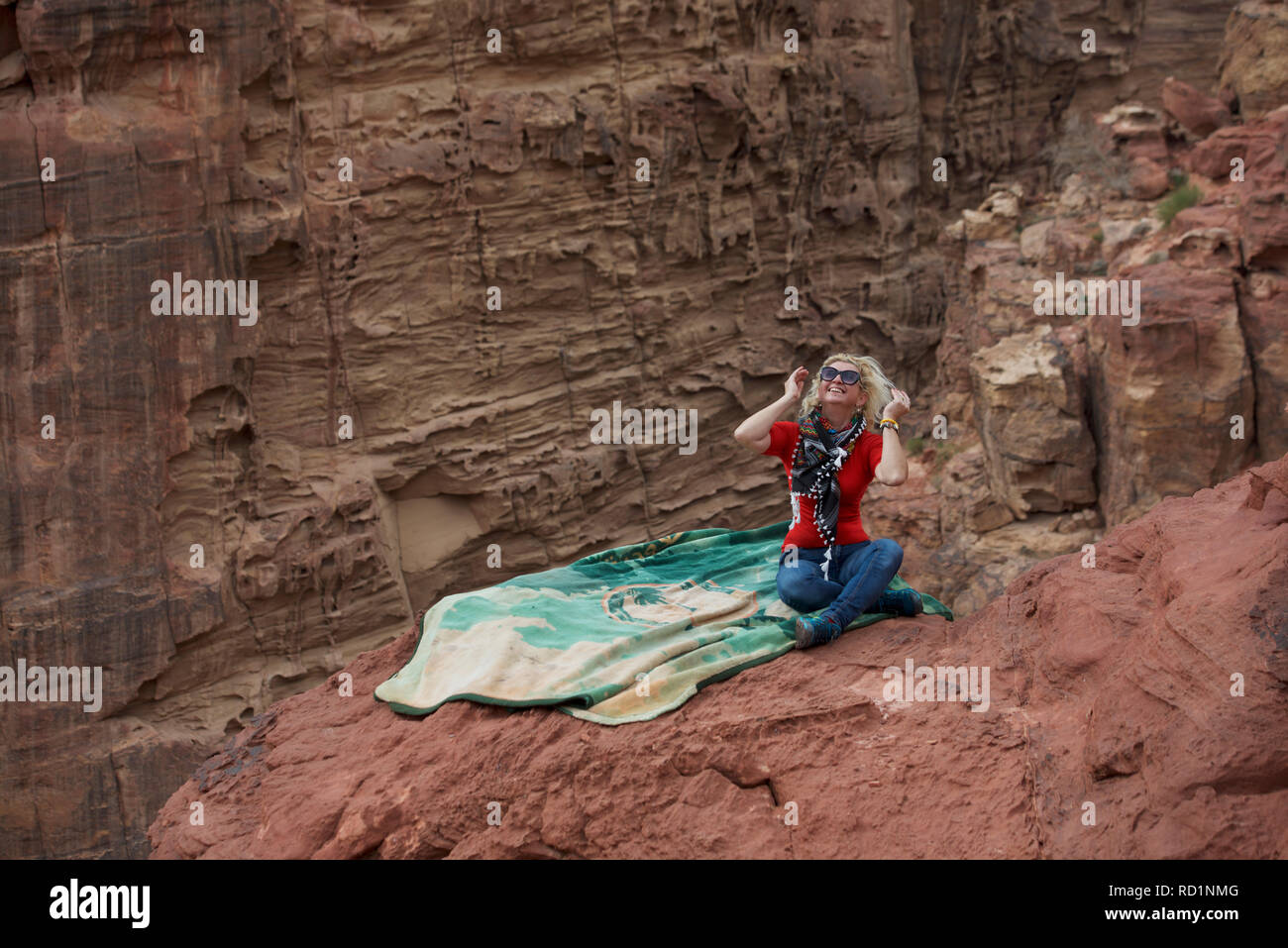 Lächelnde Frau sitzen auf den Felsen, Petra, Wadi Musa, Jordanien Stockfoto