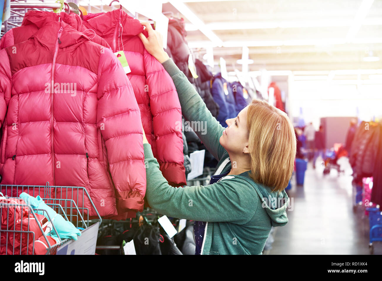 Frau wählt eine Winterjacke im Store. Stockfoto