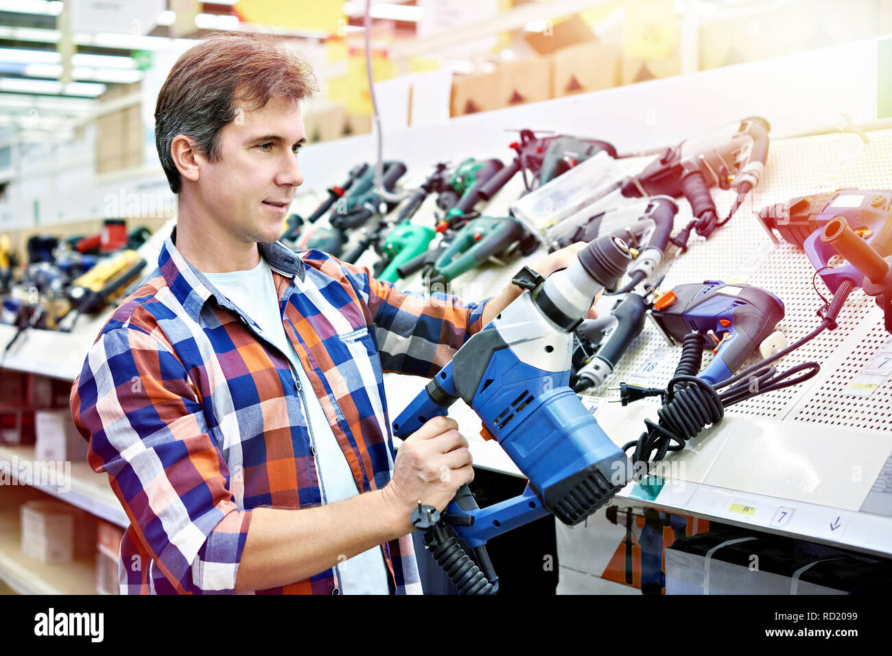 Shopping für Perforator im Baumarkt Nahaufnahme Mann Stockfoto